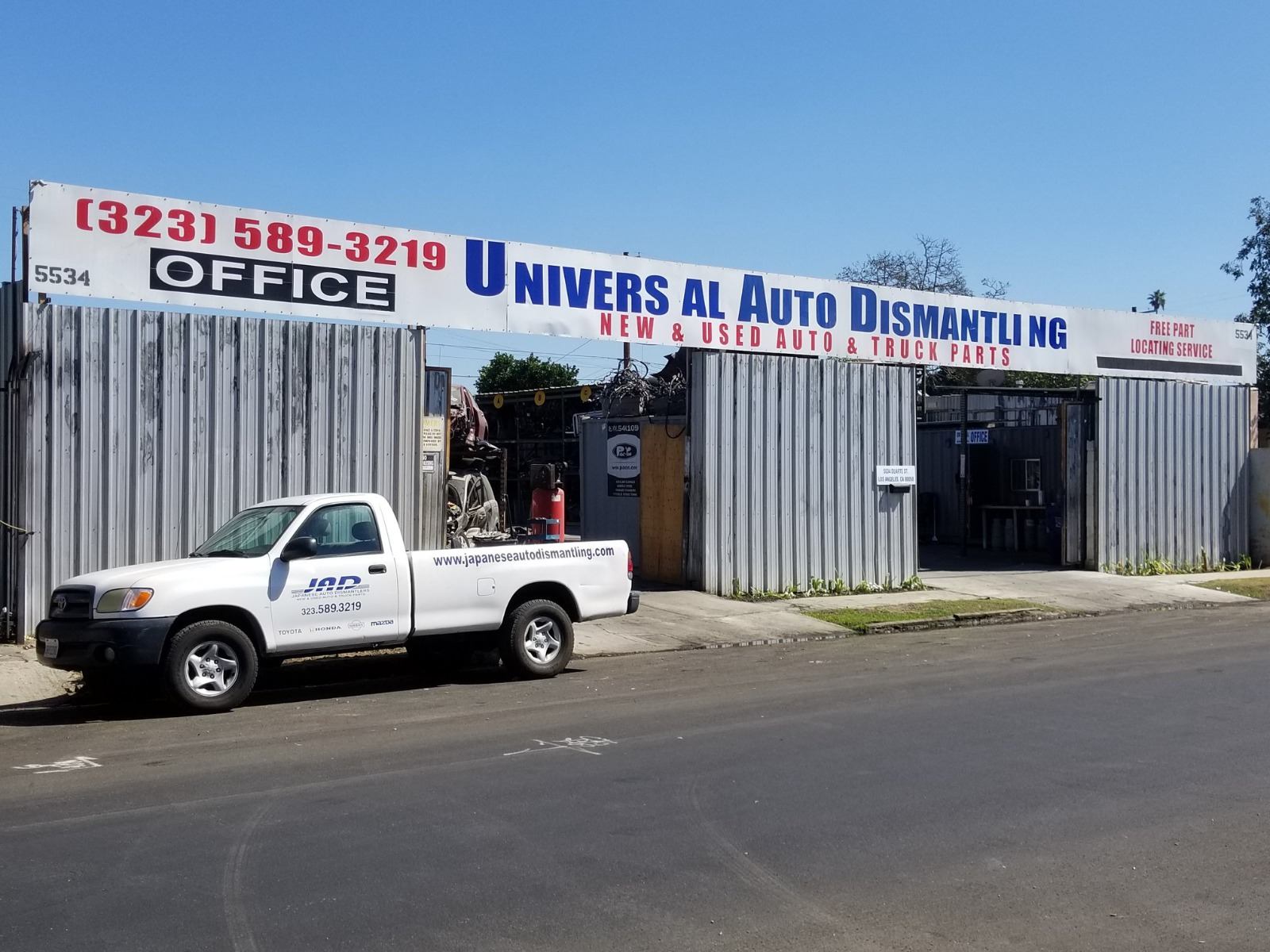 Universal Auto Dismantling storefront with pickup truck